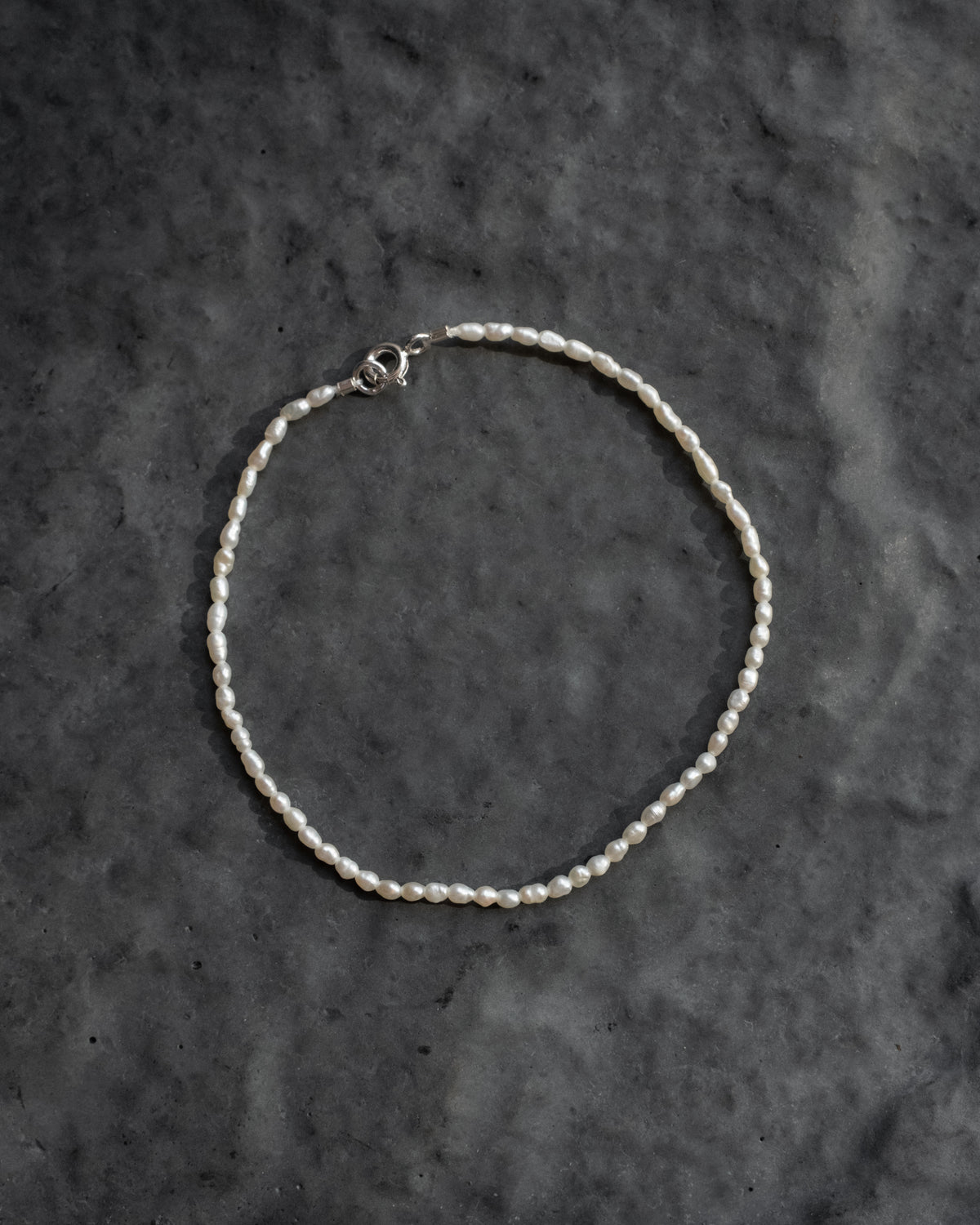 Freshwater vintage pearl bracelet with a sterling silver clasp on grey slate