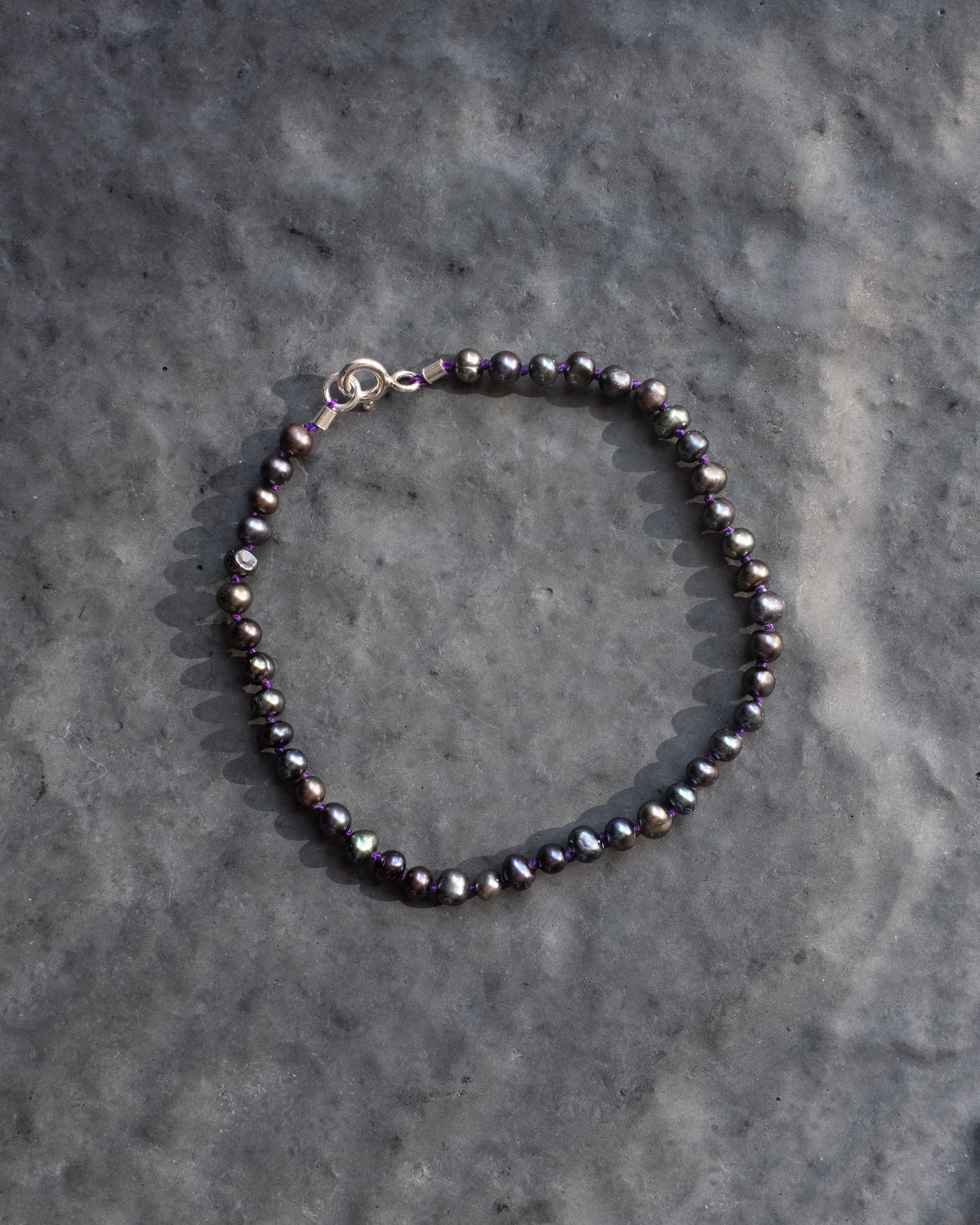 Black vintage pearl hand knotted bracelet on grey slate