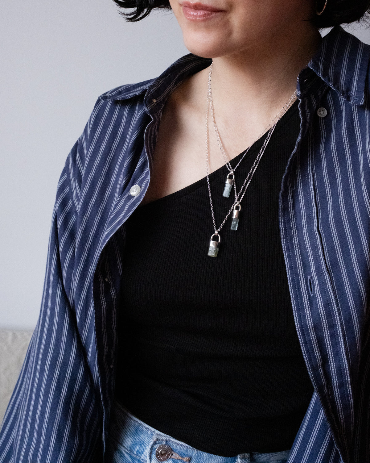 Model in a striped shirt wearing raw aquamarine sterling silver necklaces